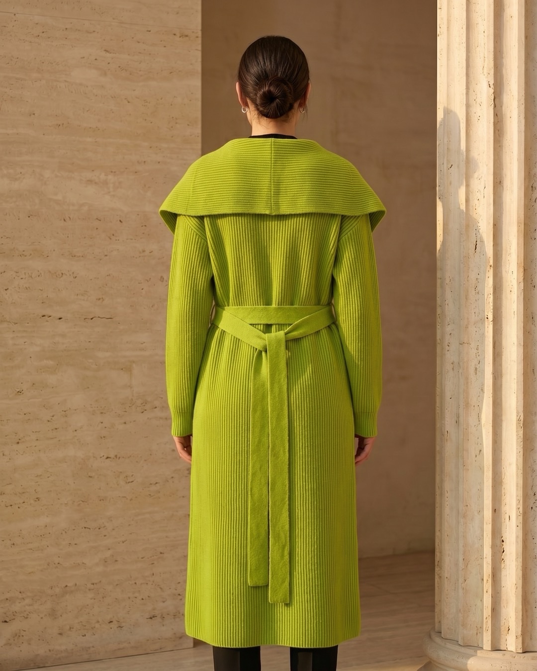 Hugo Caesar Tassi Agrippina full-length rear view showing the draped shawl collar across the back, the vertical rib and the self-tie belt knotted at the waist
