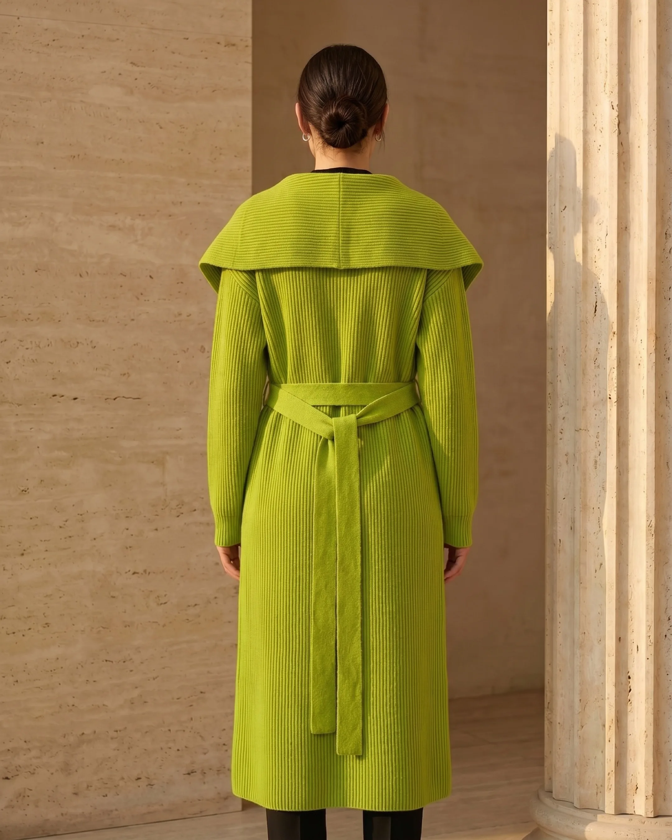 Hugo Caesar Tassi Agrippina full-length rear view showing the draped shawl collar across the back, the vertical rib and the self-tie belt knotted at the waist