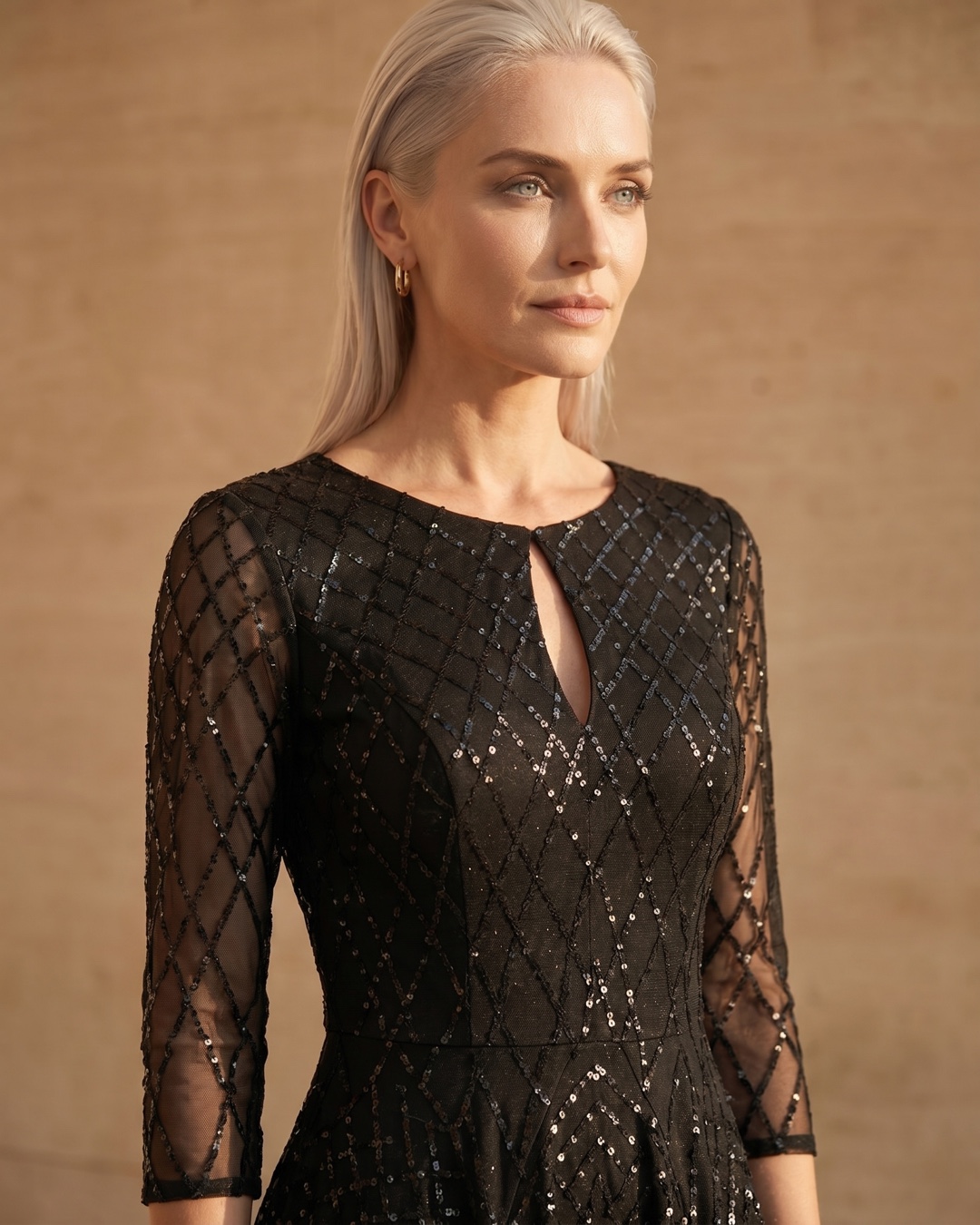 Hugo Caesar Tassi Albia close-up of the round neckline with teardrop keyhole, illusion sleeve and geometric sequin lattice in black crepe