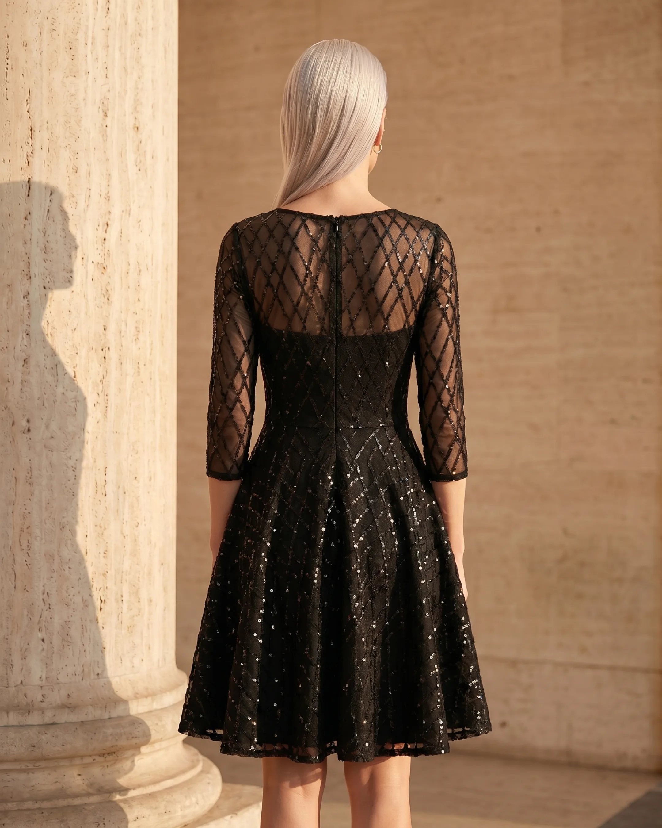 Hugo Caesar Tassi Albia full-length rear view showing the sheer illusion sequin upper back, centre-back zip and flared skirt of the cocktail dress