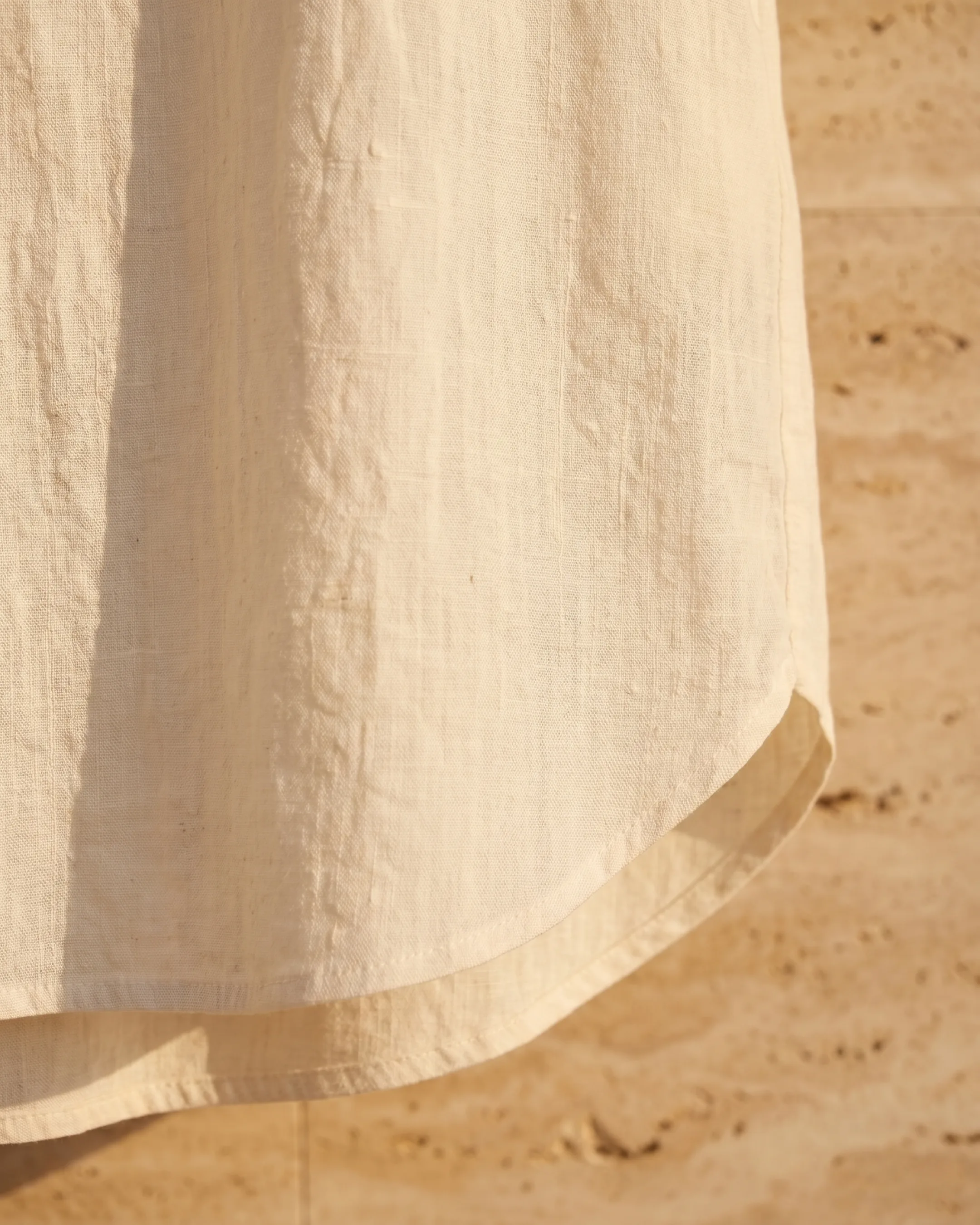Hugo Caesar Tassi Antonia fabric macro of slubby ivory cotton-linen and the curved shirttail hem