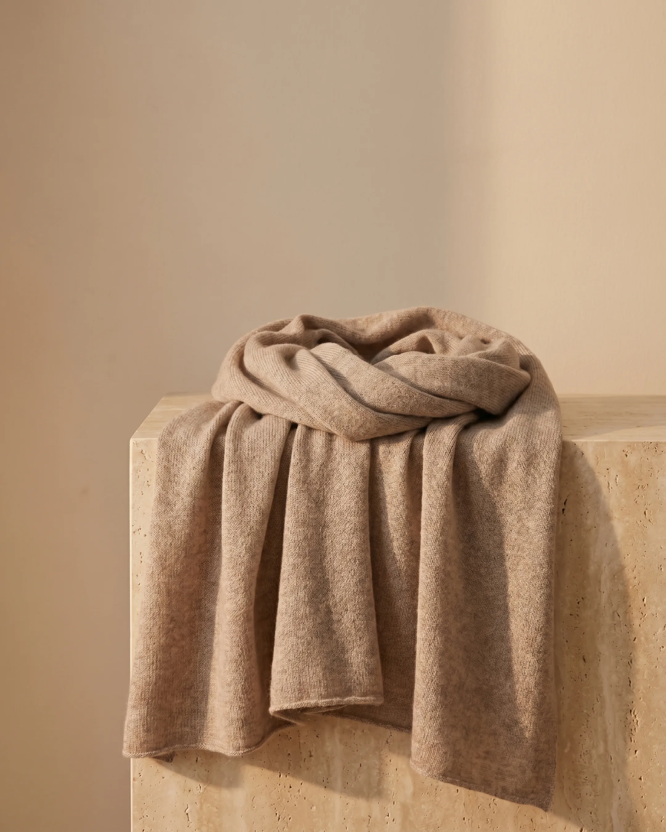 Hugo Caesar Tassi Aquileia fine cashmere evening stole in Travertine, softly draped on a warm travertine plinth