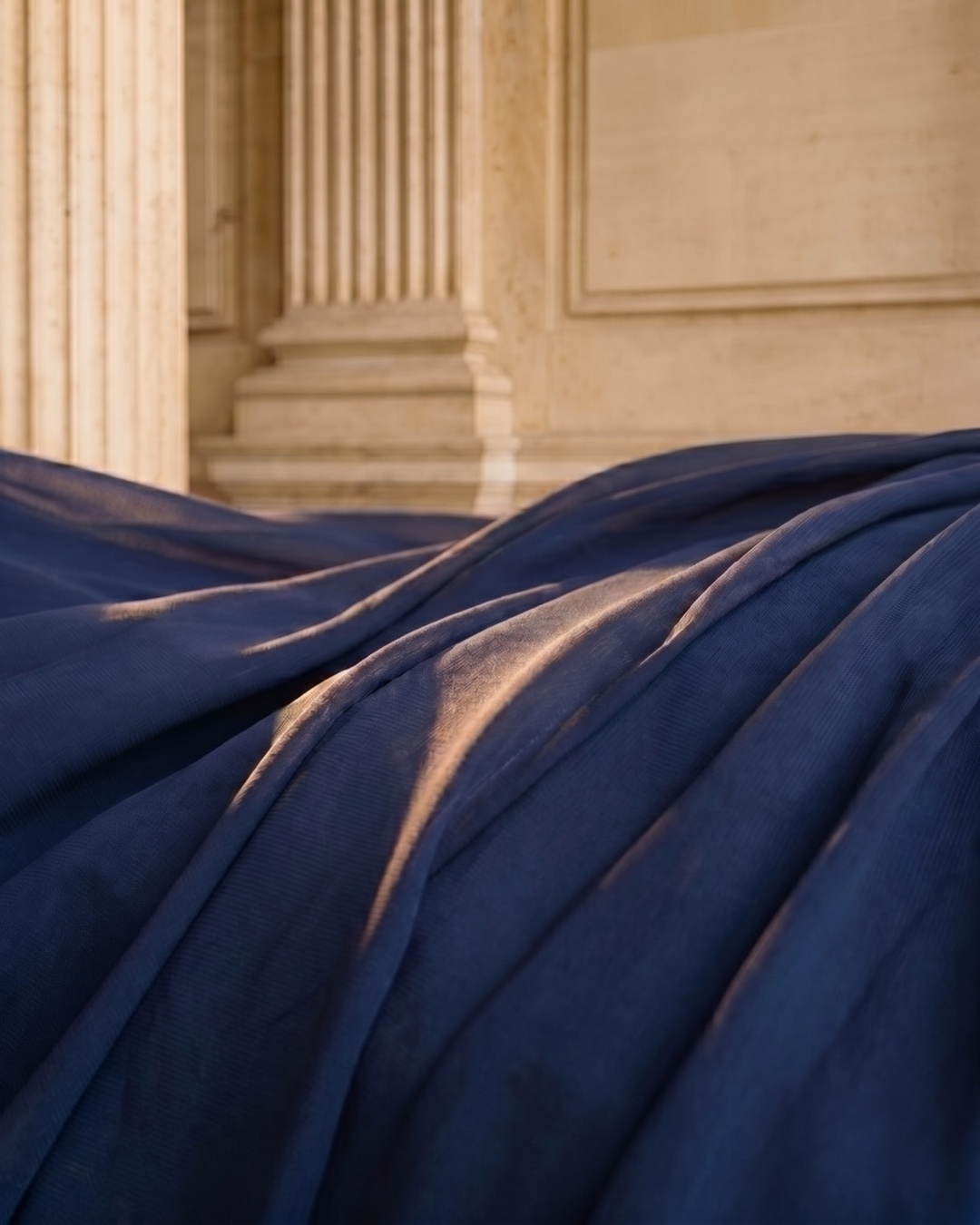 Macro detail of the Hugo Caesar Tassi Cassia gown's fluid Cobalto chiffon and soft pleated folds