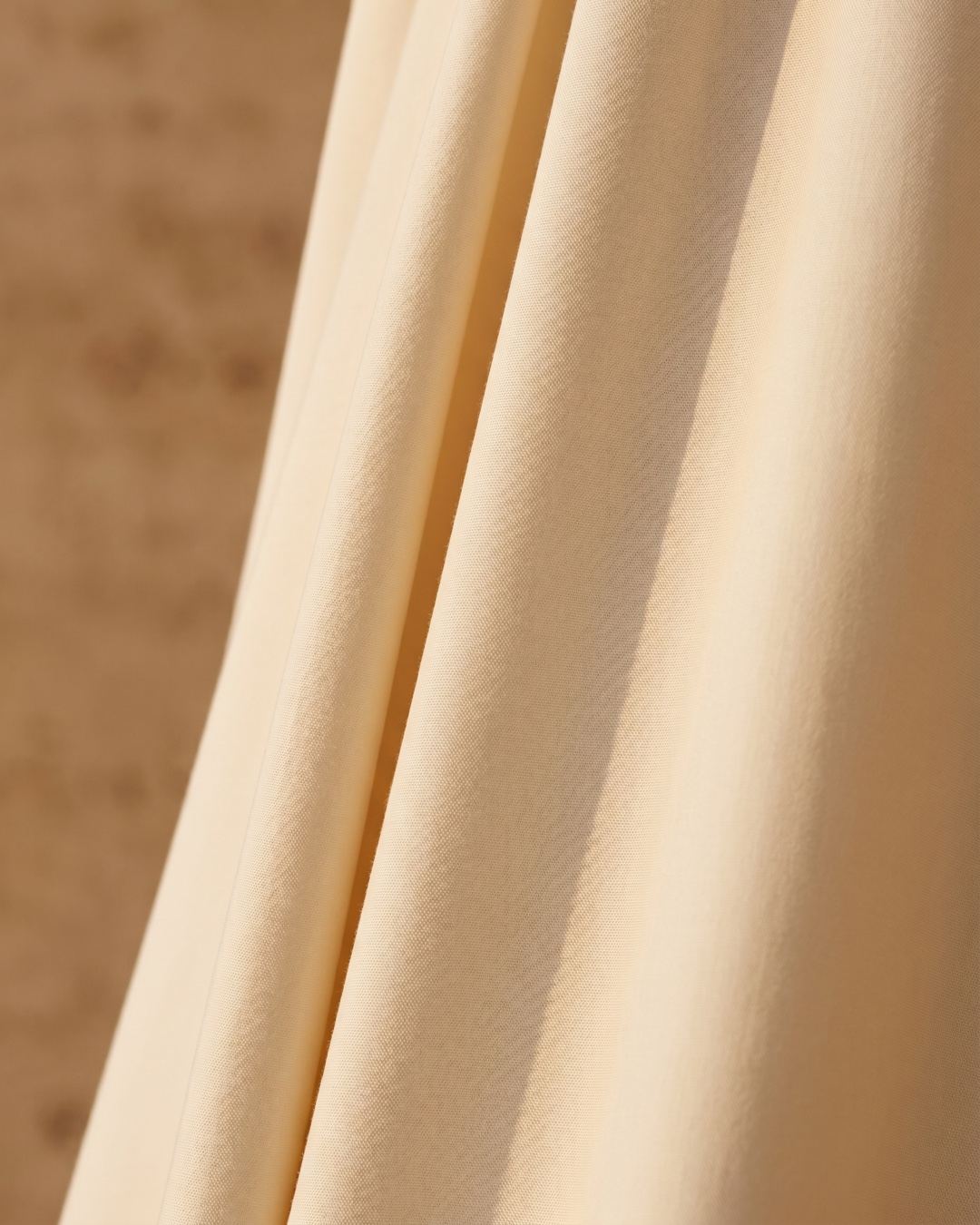 Hugo Caesar Tassi Drusilla cream poplin fabric, macro showing the structured matte weave