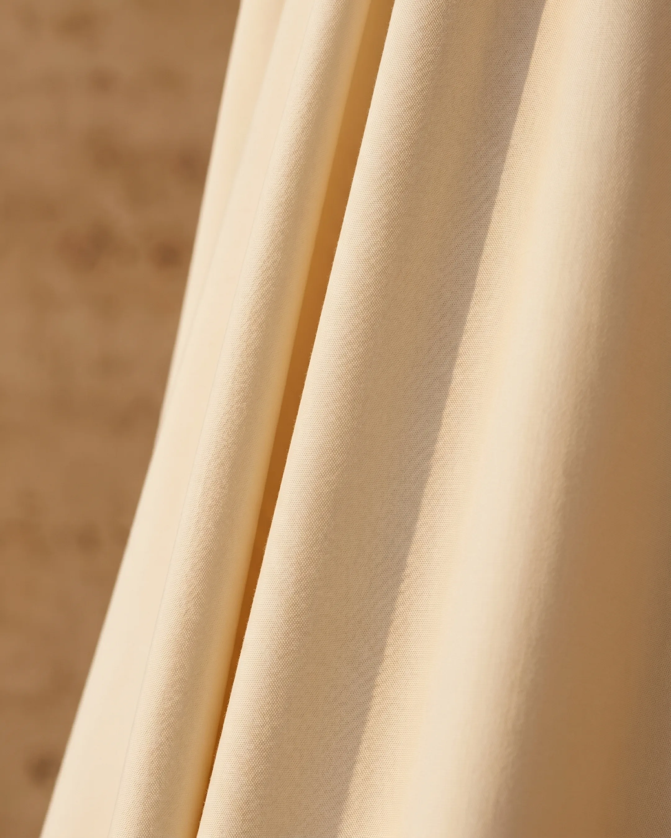 Hugo Caesar Tassi Drusilla cream poplin fabric, macro showing the structured matte weave