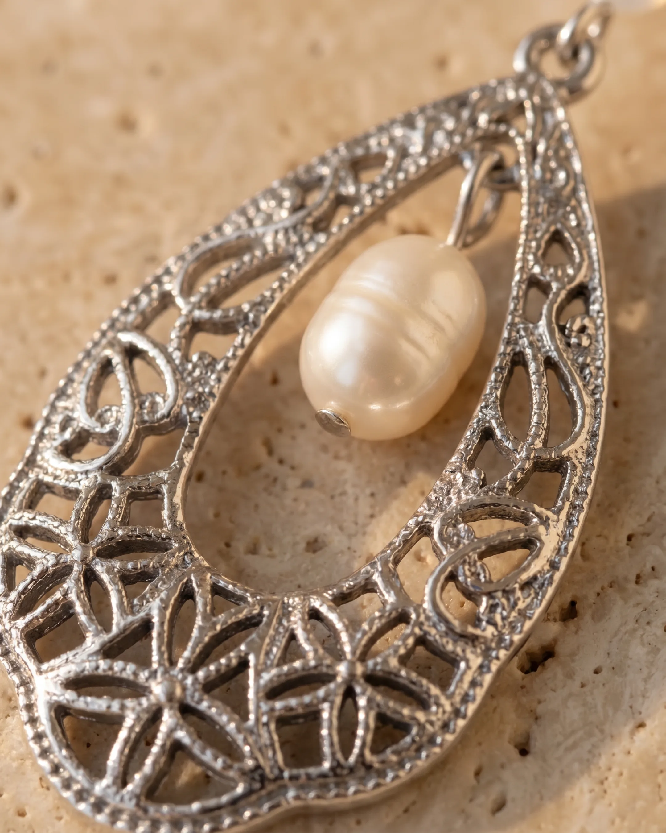 Hugo Caesar Tassi Fortuna macro of the antiqued silver openwork filigree teardrop and the natural cream freshwater pearl suspended inside