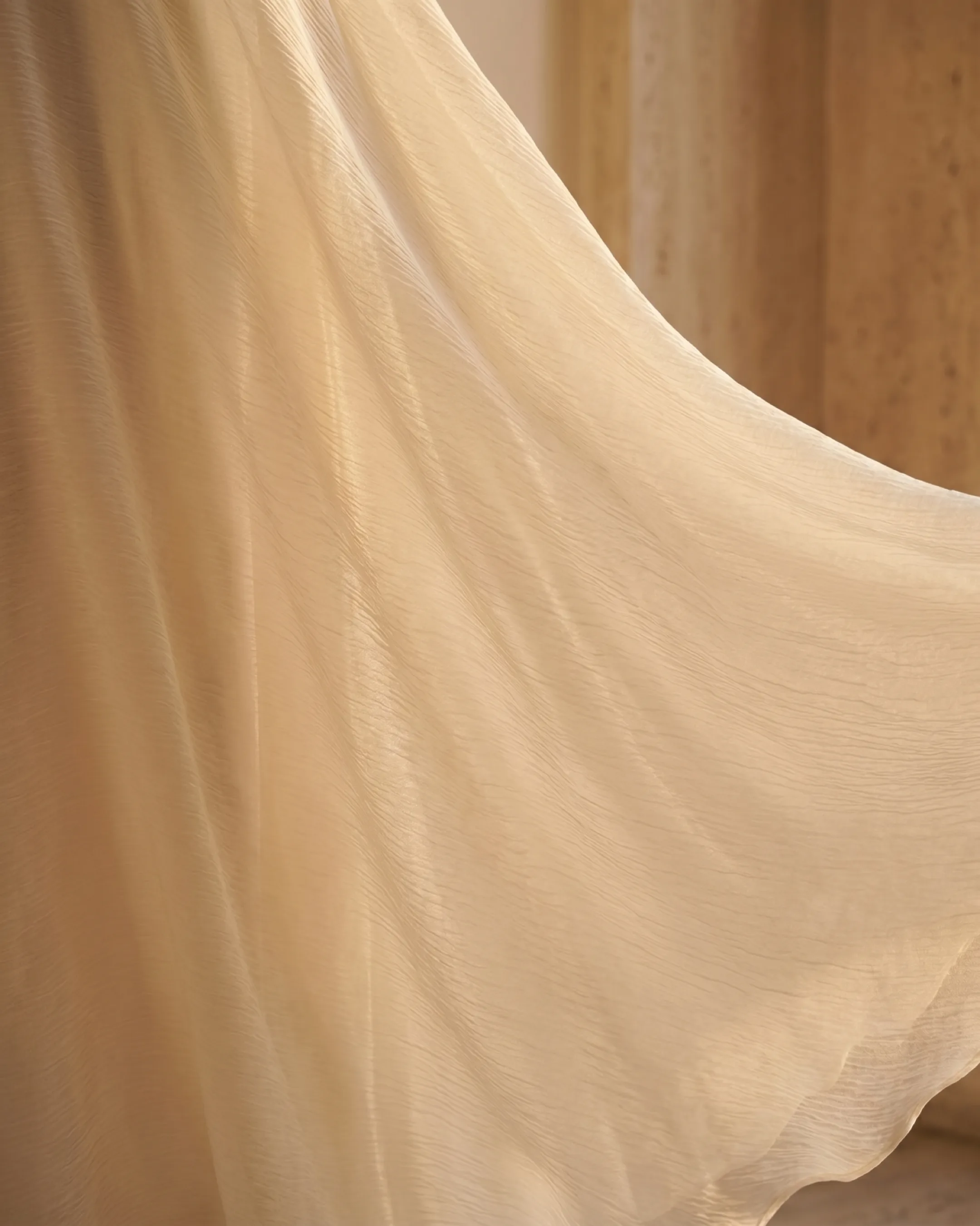 Hugo Caesar Tassi Fulvia macro of the lightly crinkled ivory-cream crepe, soft folds catching warm afternoon light