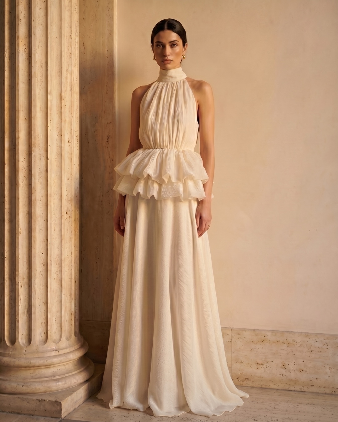 Hugo Caesar Tassi Fulvia stand-collar crepe dress photographed beside a fluted travertine column in soft golden afternoon light