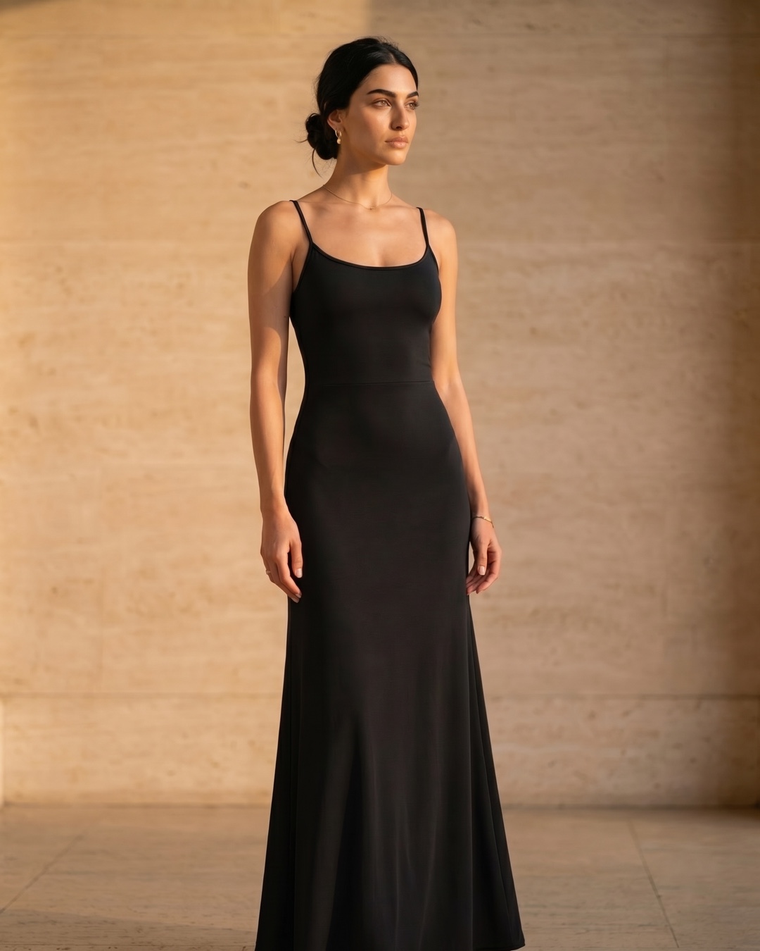 Hugo Caesar Tassi Galla A-line strap dress photographed beside a fluted travertine column in soft golden afternoon light