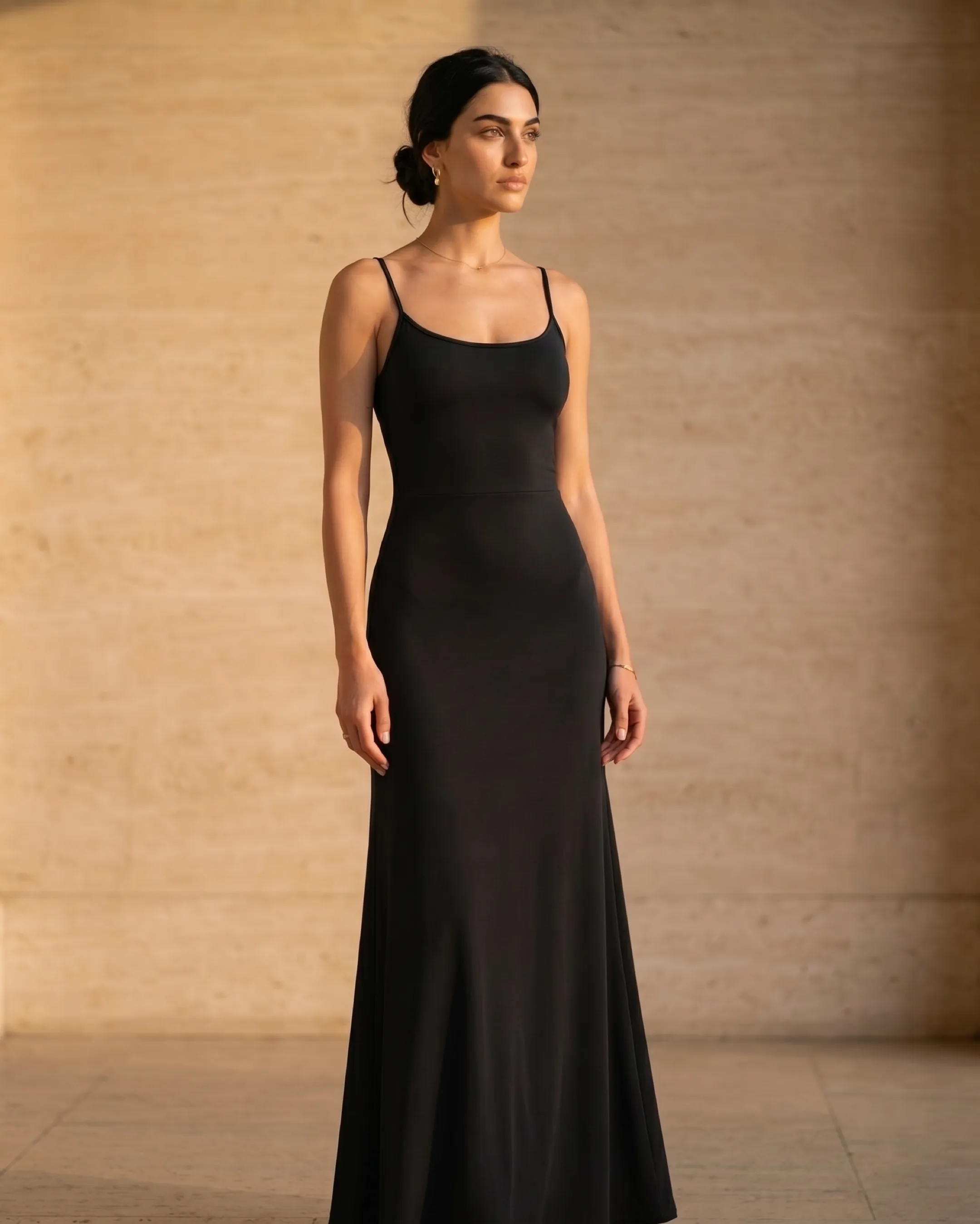 Hugo Caesar Tassi Galla A-line strap dress photographed beside a fluted travertine column in soft golden afternoon light