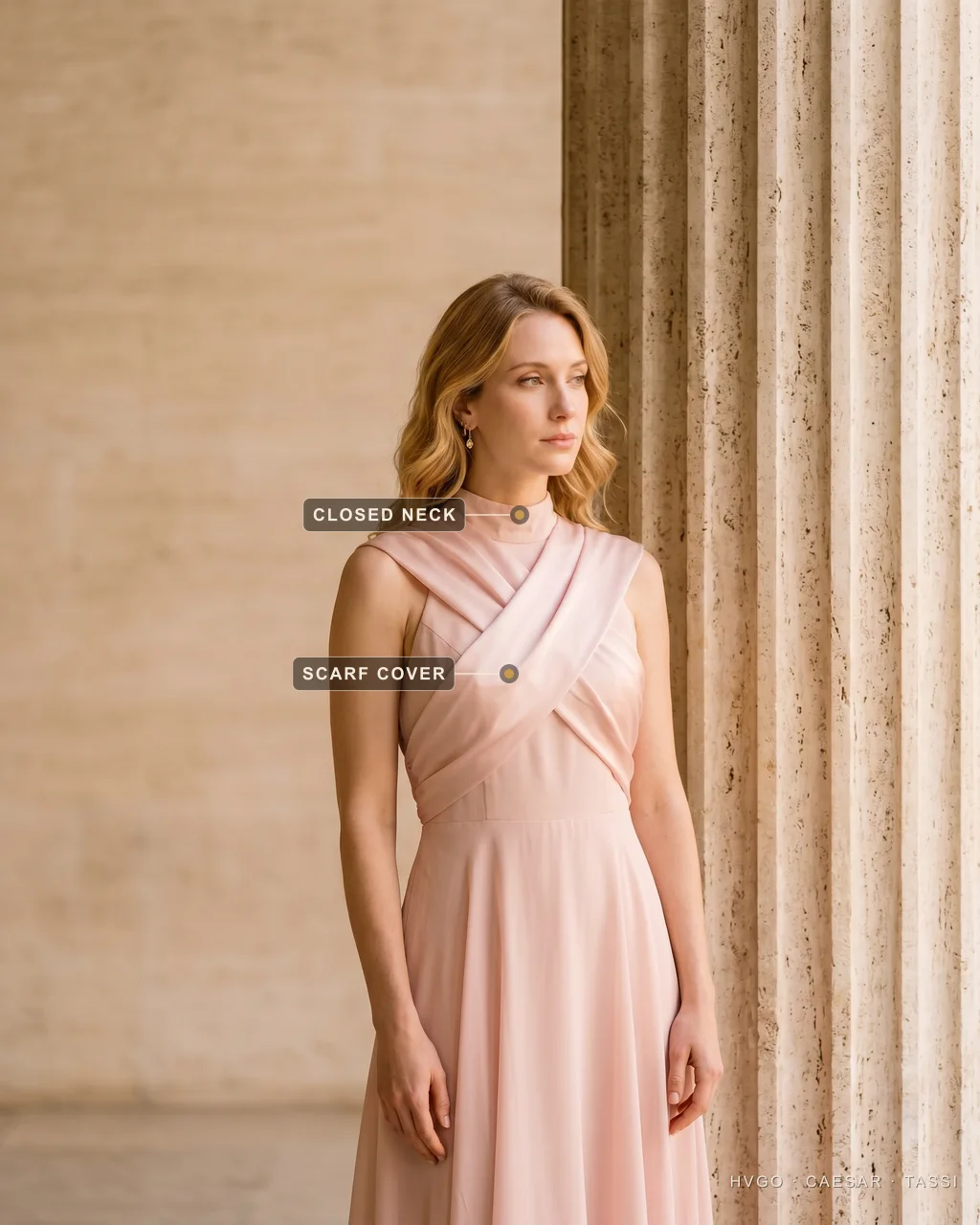 Covered Shoulders for a Christening: a Silk Scarf Over Soft-Pink Chiffon — Hugo Caesar Tassi Bianca, a golden-blonde house model, in a three-quarter contrapposto turn off-centre beside a fluted Roman travertine column, wearing a Hugo Caesar Tassi Cipria soft-pink chiffon christening midi with a bias-cut silk scarf, labelled to show the scarf crossed over the shoulders for coverage and the closed high neckline