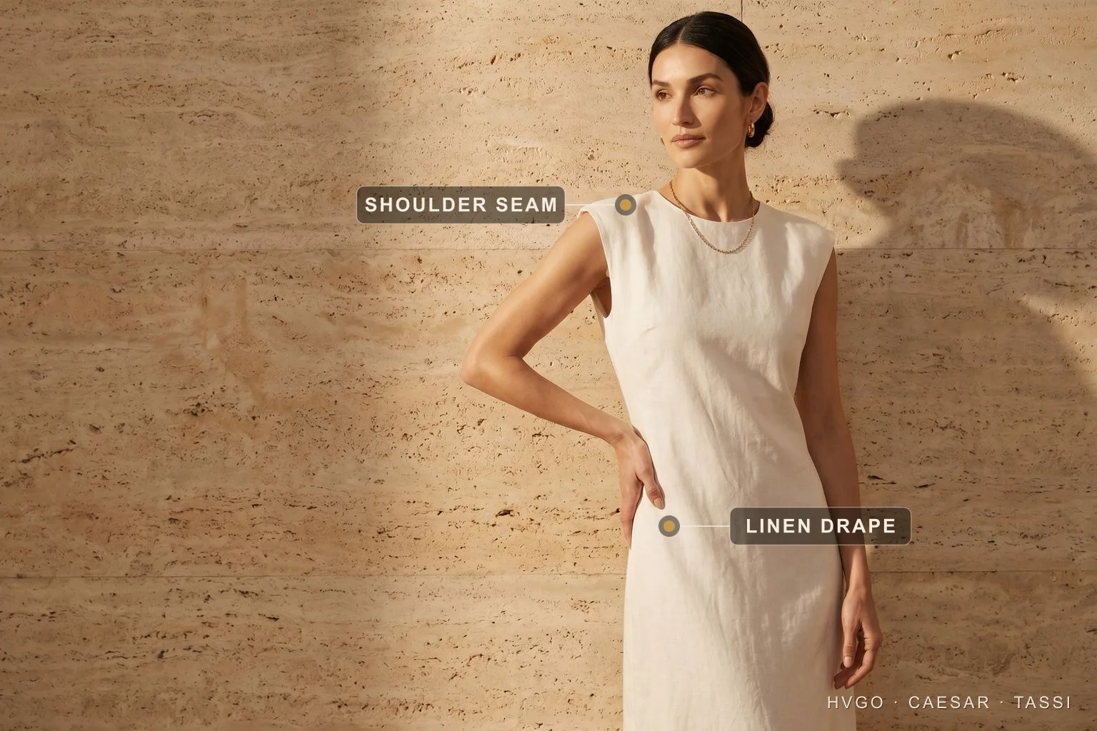 Italian style for women, la bella figura in an Avorio linen midi | Hugo Caesar Tassi Roman-Italian model in a soft Avorio ivory Pomponia relaxed linen midi dress, off-centre beside a sunlit travertine wall; gilt labels mark the clean shoulder seam and the natural linen drape of the skirt.