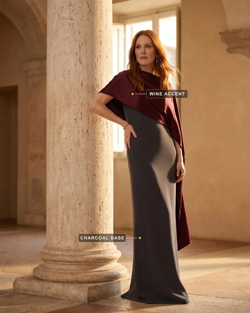 Charcoal and wine old-money colour palette — Hugo Caesar Tassi An auburn-haired woman in a charcoal column evening gown with a deep wine silk stole, beside a travertine column, labelled to show the wine accent and the charcoal base