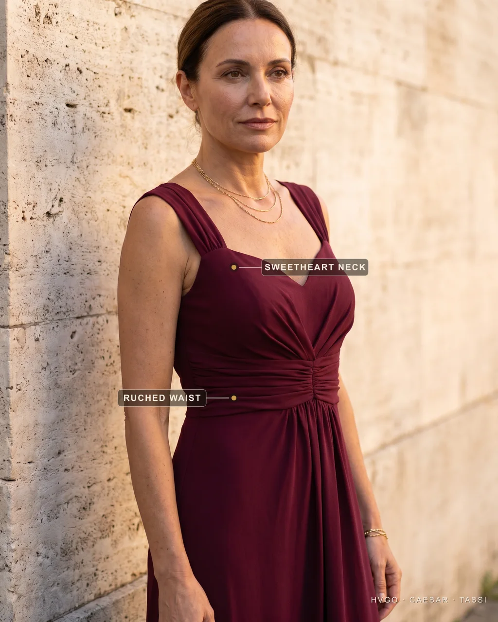 Close view of a woman with a rectangle figure in a Hugo Caesar Tassi wine crepe gown with a sweetheart neckline and ruched waist, labelled to show the sweetheart rounding the bust and the ruching creating a waist