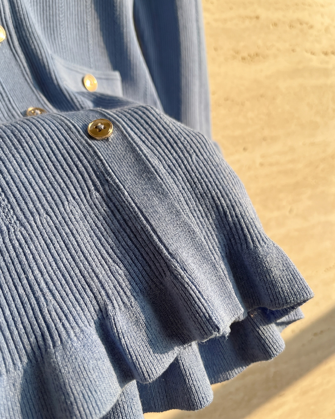 Macro detail of the Hugo Caesar Tassi Hortensia dress's fine ribbed dusty Cobalto blue viscose knit, knife-pleating and ruffled flounce hem