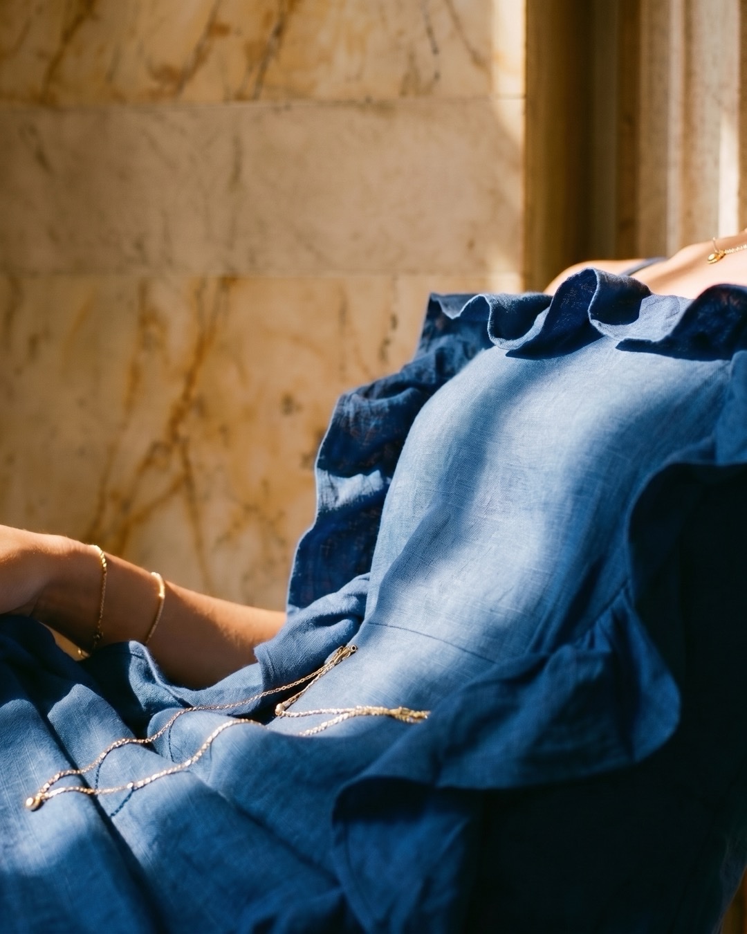 Macro detail of the Hugo Caesar Tassi Junia dress's matte Cobalto linen-look crepe and soft ruffle frill