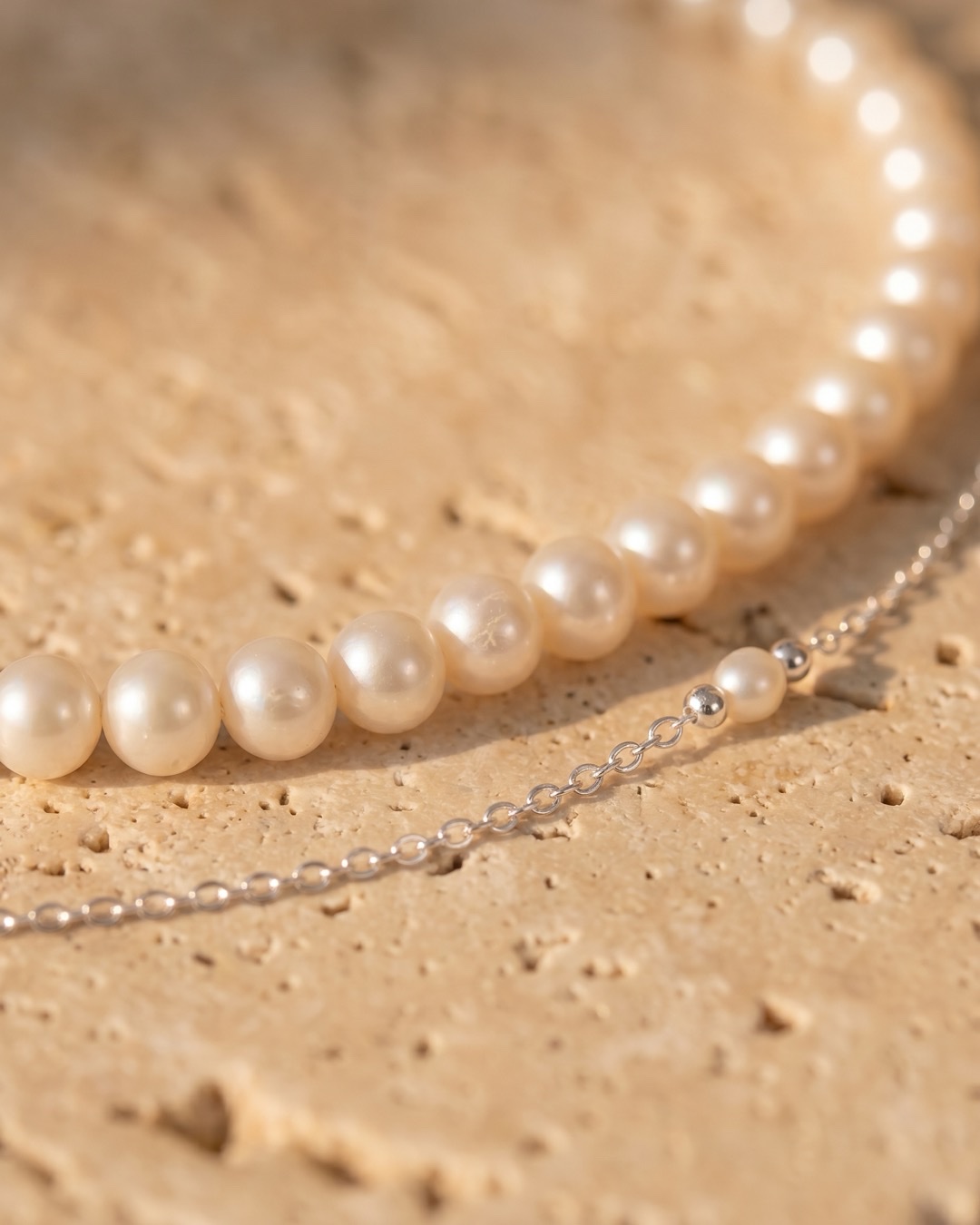 Hugo Caesar Tassi Laurea macro of the round natural freshwater pearls and the fine polished silver chain with a pearl-and-silver bead station