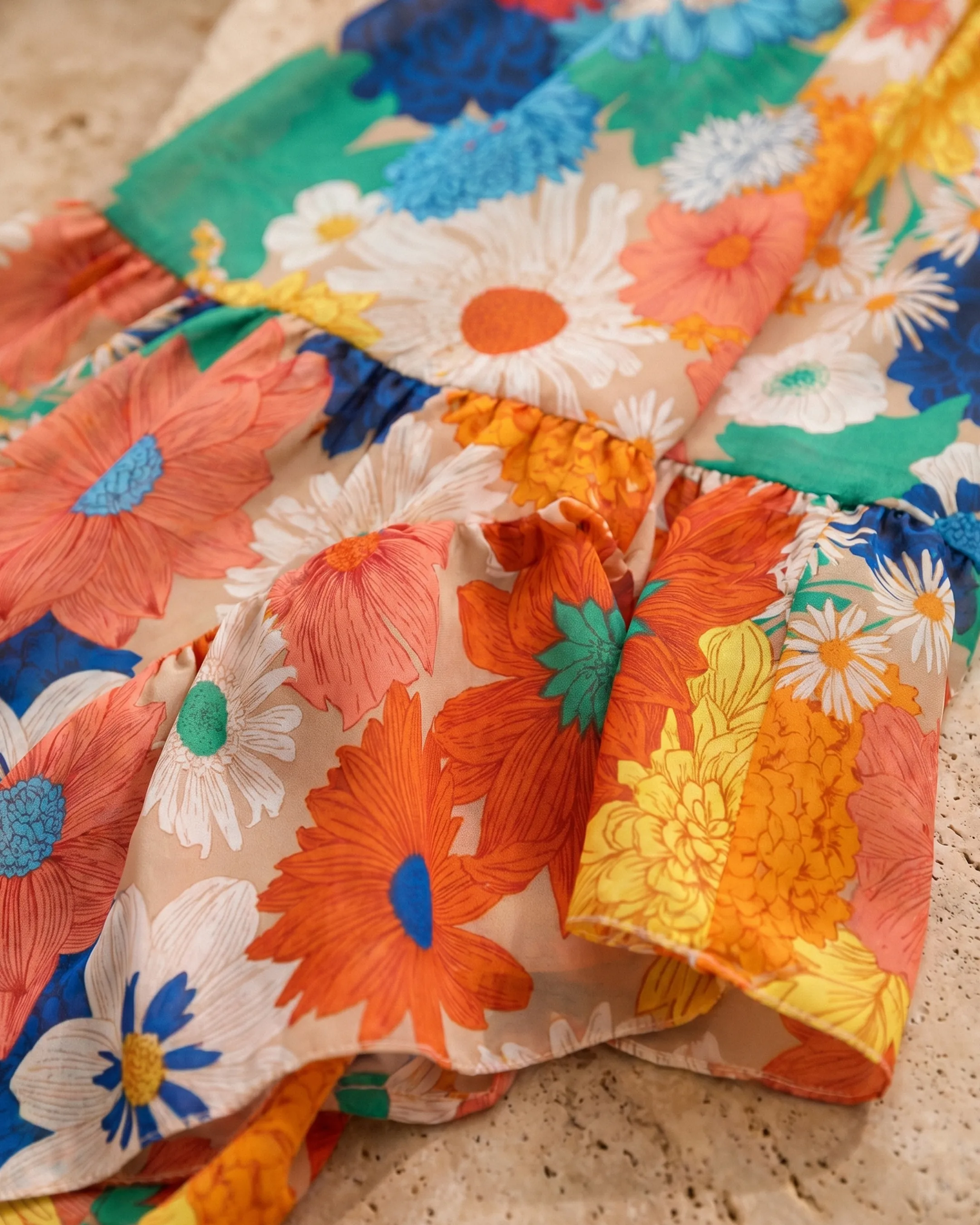 Macro of the Livilla multicolor floral-print chiffon and tiered ruffled hem on Roman travertine, Hugo Caesar Tassi