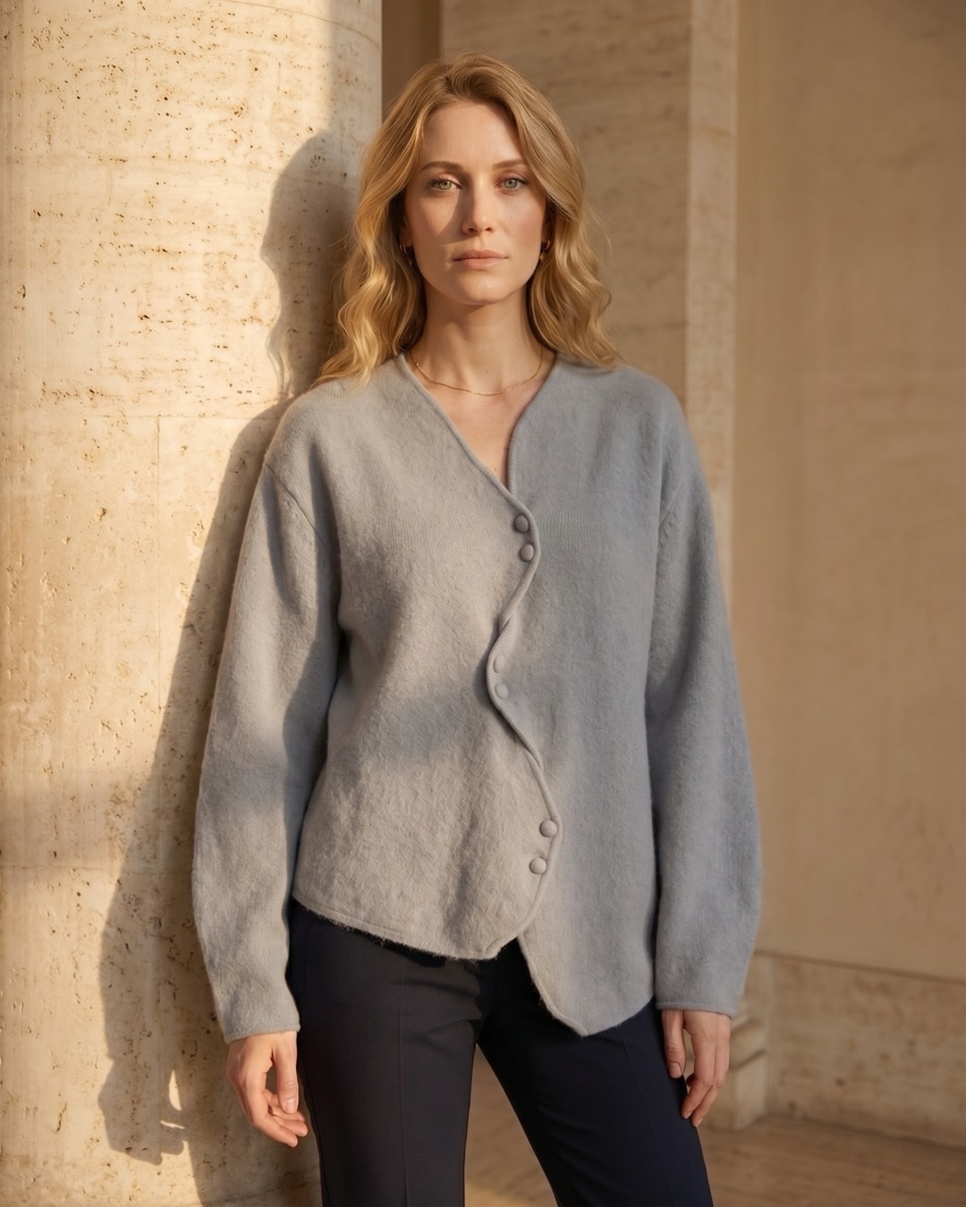 Hugo Caesar Tassi Lucretia cardigan editorial beside a fluted travertine column