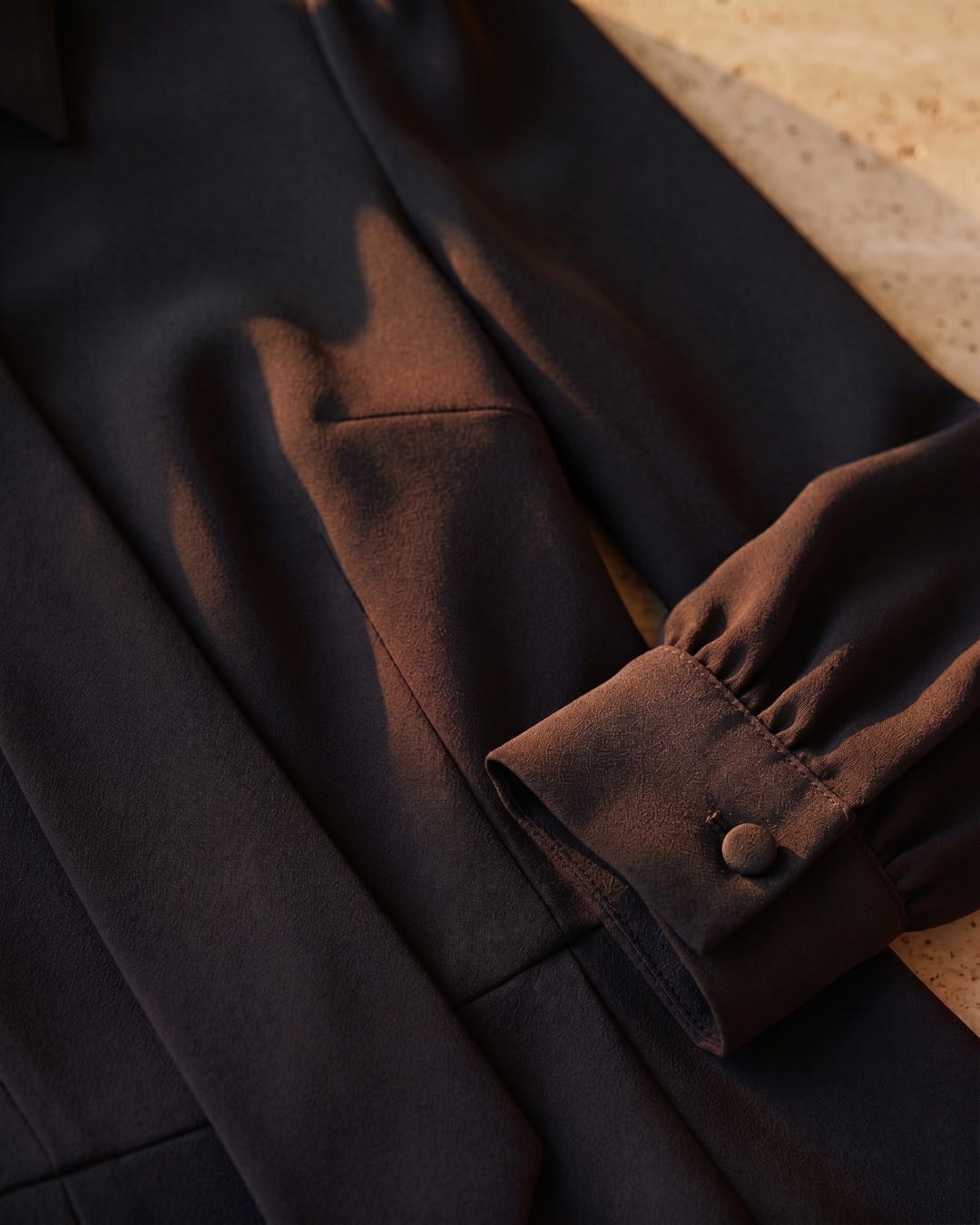 Hugo Caesar Tassi Octavia fabric macro of matte black crepe with a buttoned cuff and seam