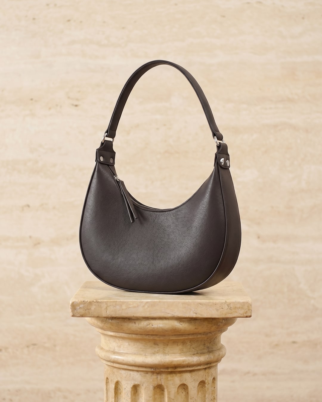 Hugo Caesar Tassi minimalist crescent leather shoulder bag in Basalt — studio packshot, Hugo Caesar Tassi