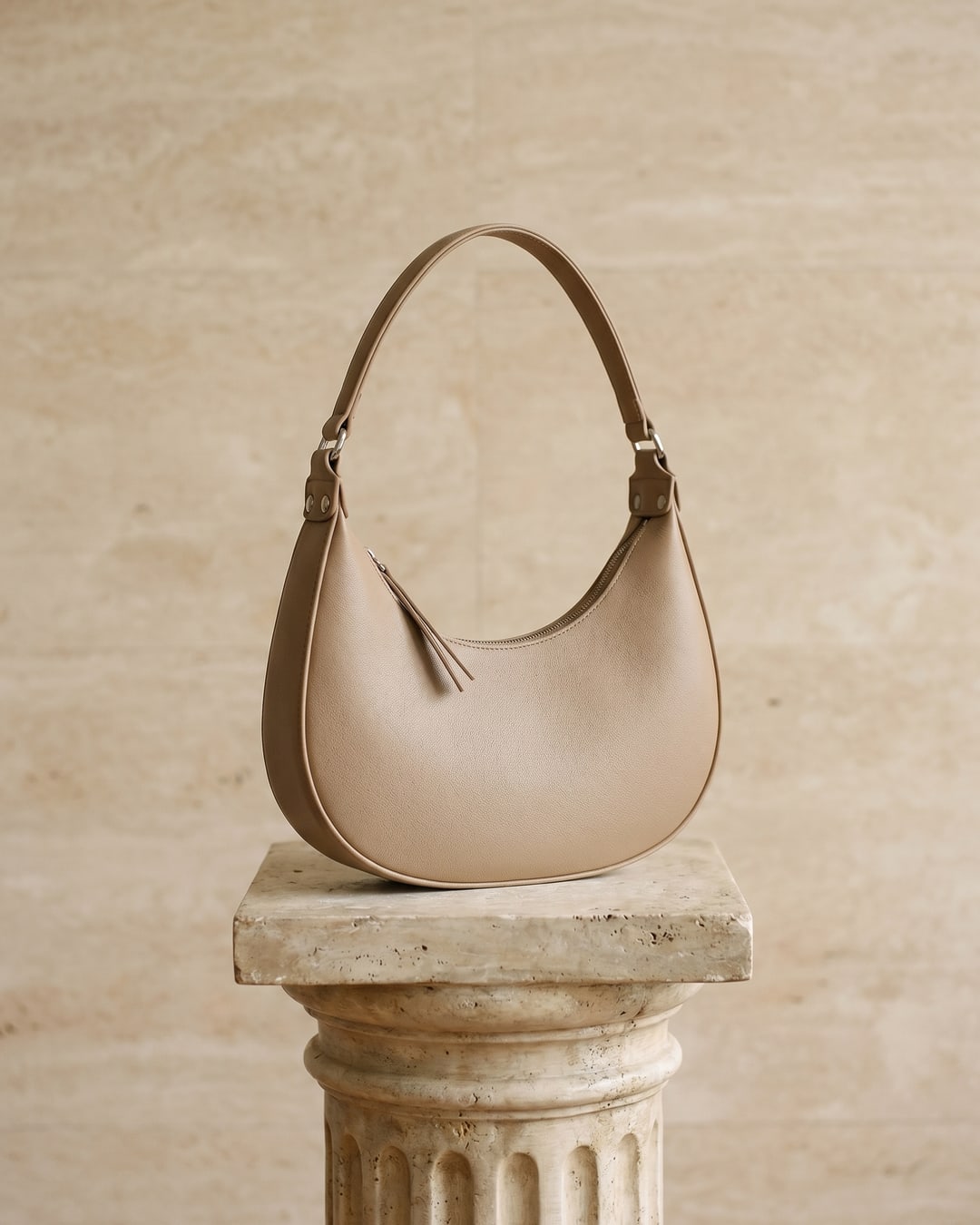 Hugo Caesar Tassi minimalist crescent leather shoulder bag in Travertine — studio packshot, Hugo Caesar Tassi