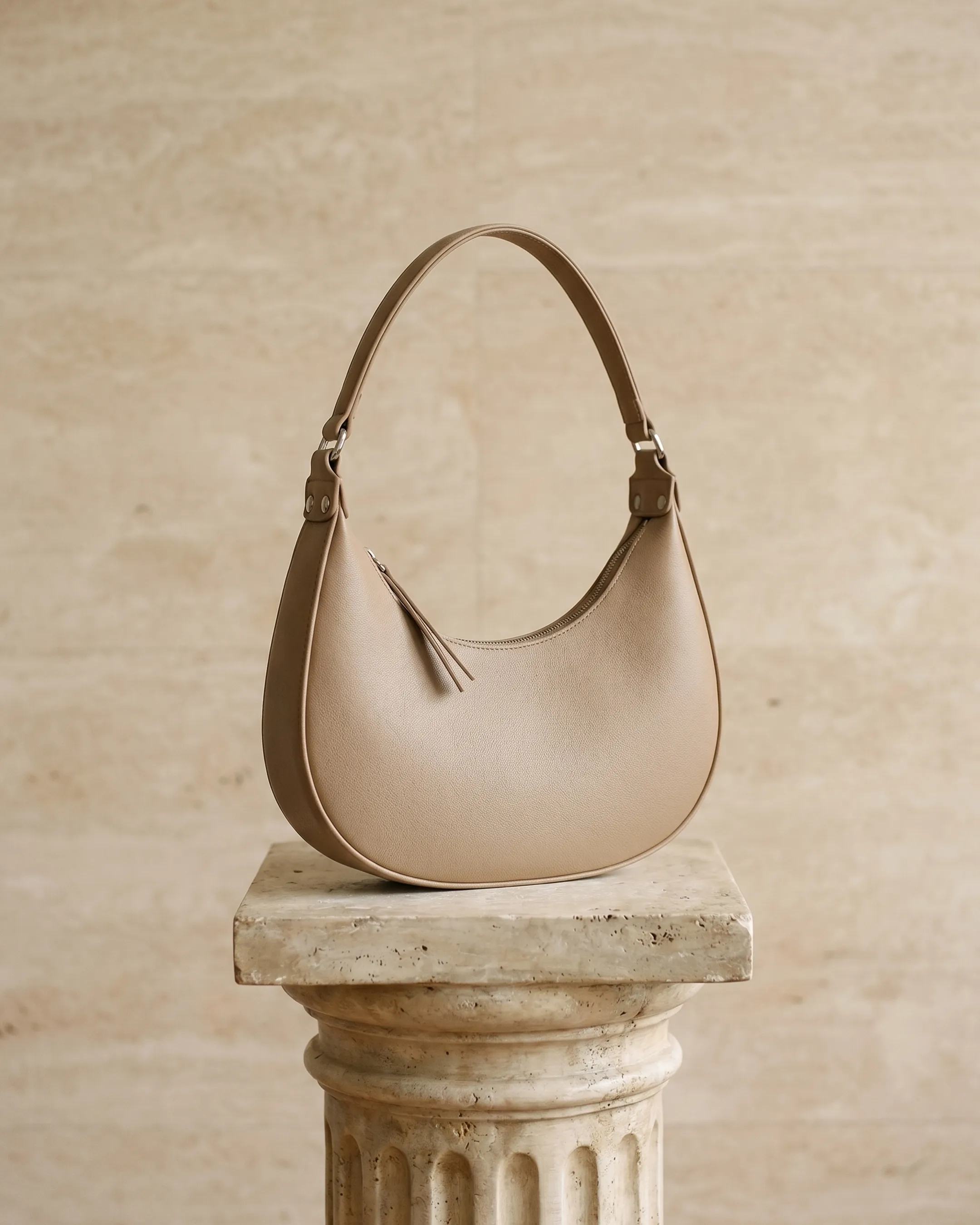 Hugo Caesar Tassi minimalist crescent leather shoulder bag in Travertine — studio packshot, Hugo Caesar Tassi