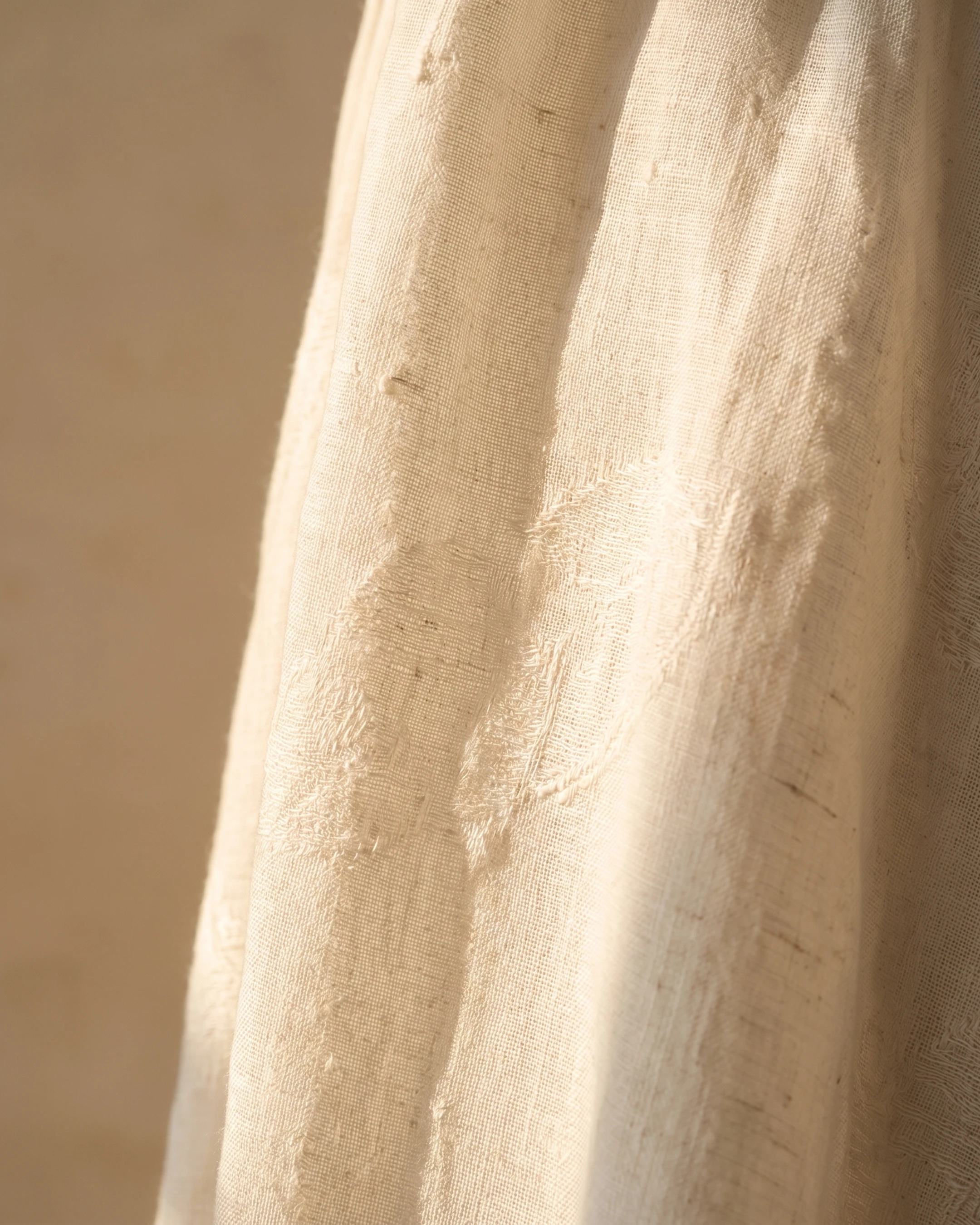 Macro detail of the Hugo Caesar Tassi Pomponia dress's natural Avorio ivory linen weave with its faint tone-on-tone woven floral