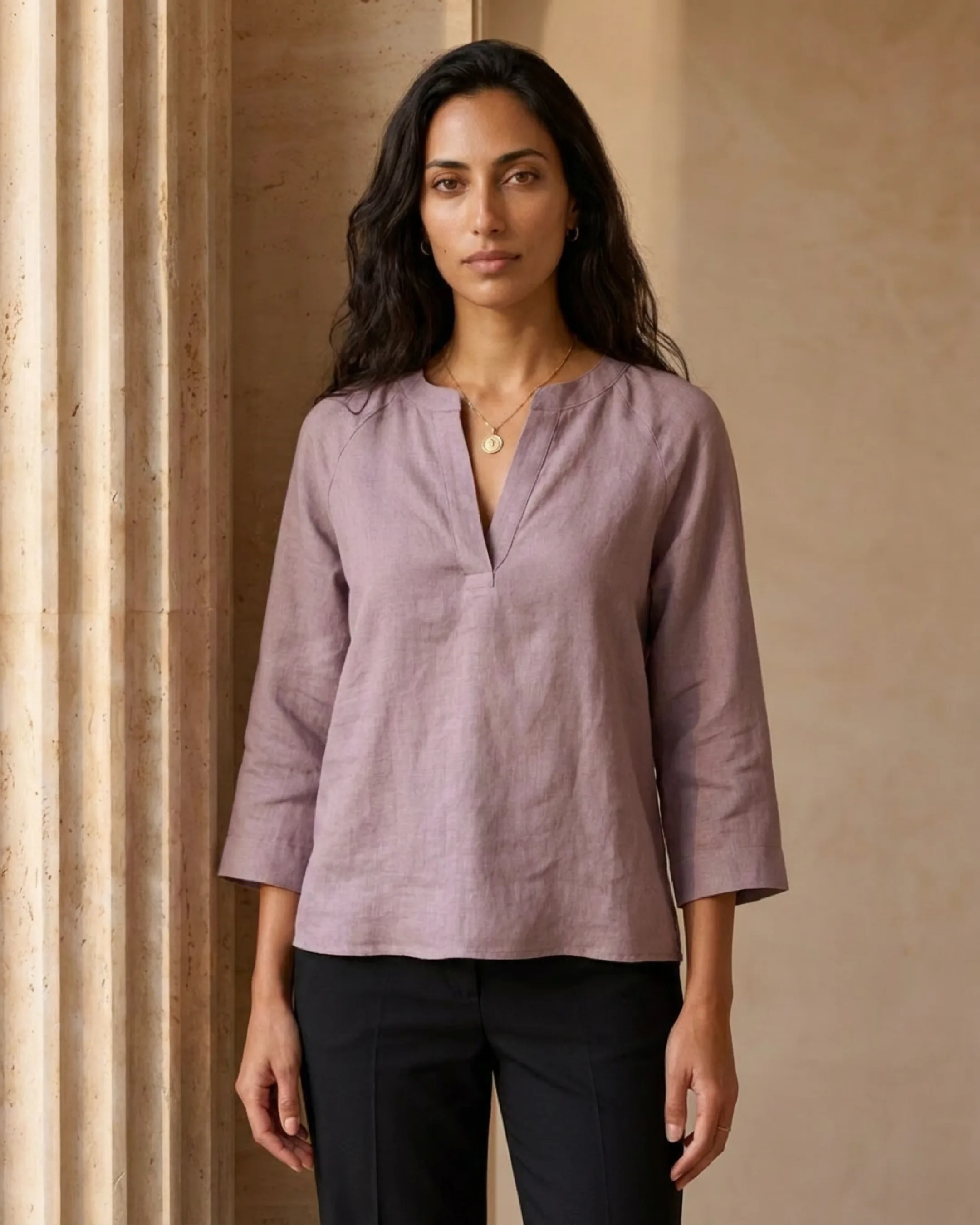 Hugo Caesar Tassi Roscia editorial three-quarter of the lilac ramie blouse beside a fluted travertine column in golden light