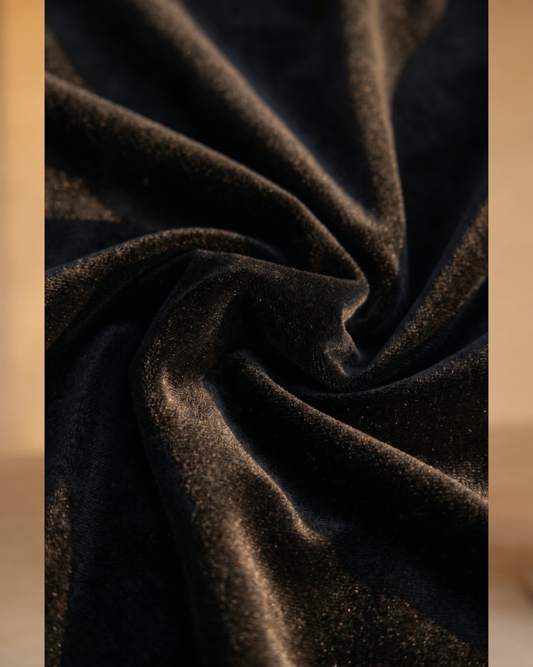 Hugo Caesar Tassi Rufina macro of plush black velvet in soft folds, the pile catching golden afternoon light