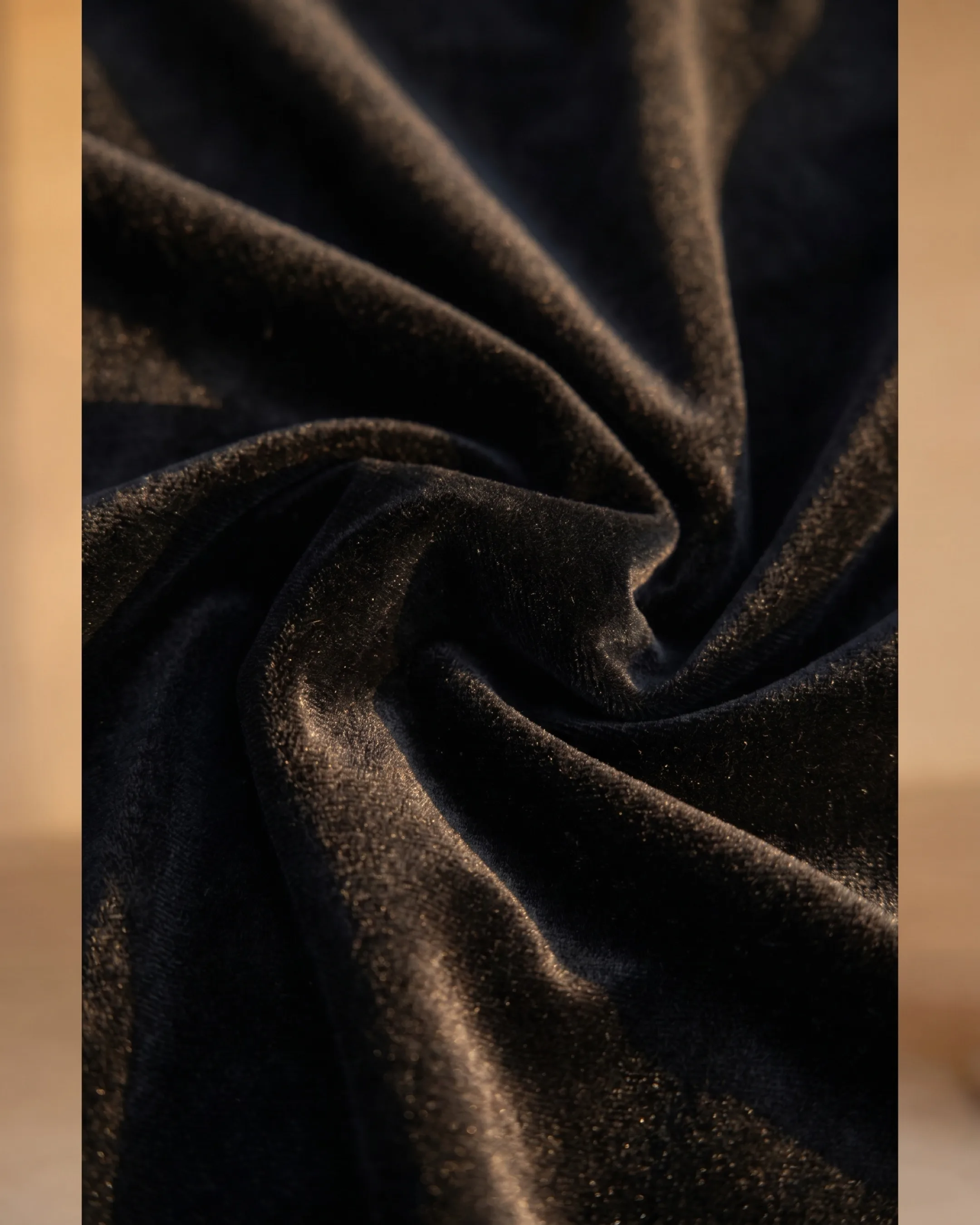 Hugo Caesar Tassi Rufina macro of plush black velvet in soft folds, the pile catching golden afternoon light