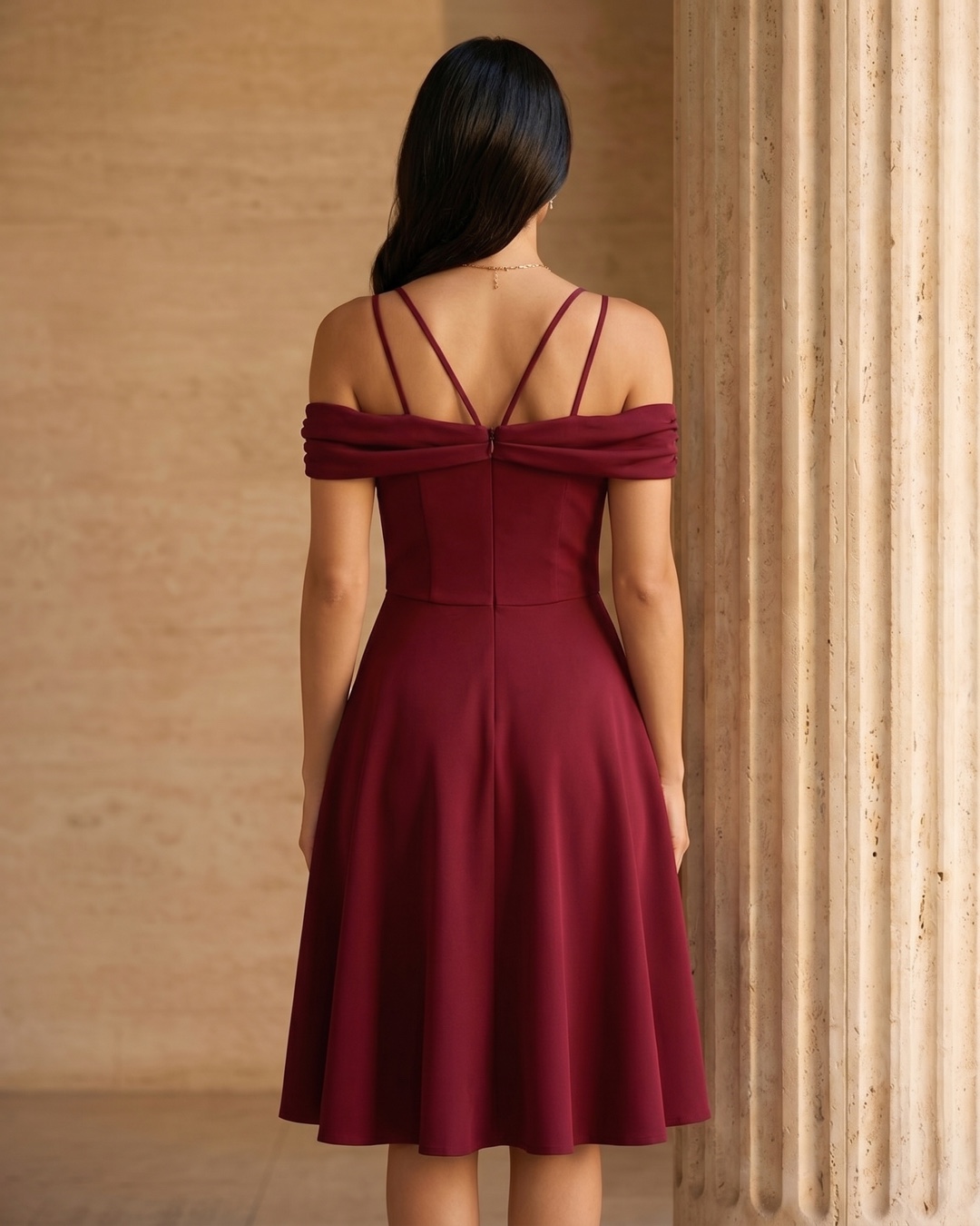 Hugo Caesar Tassi Sabina full-length rear view showing the off-shoulder band, crossed straps, fitted back bodice and flared skirt of the cocktail dress