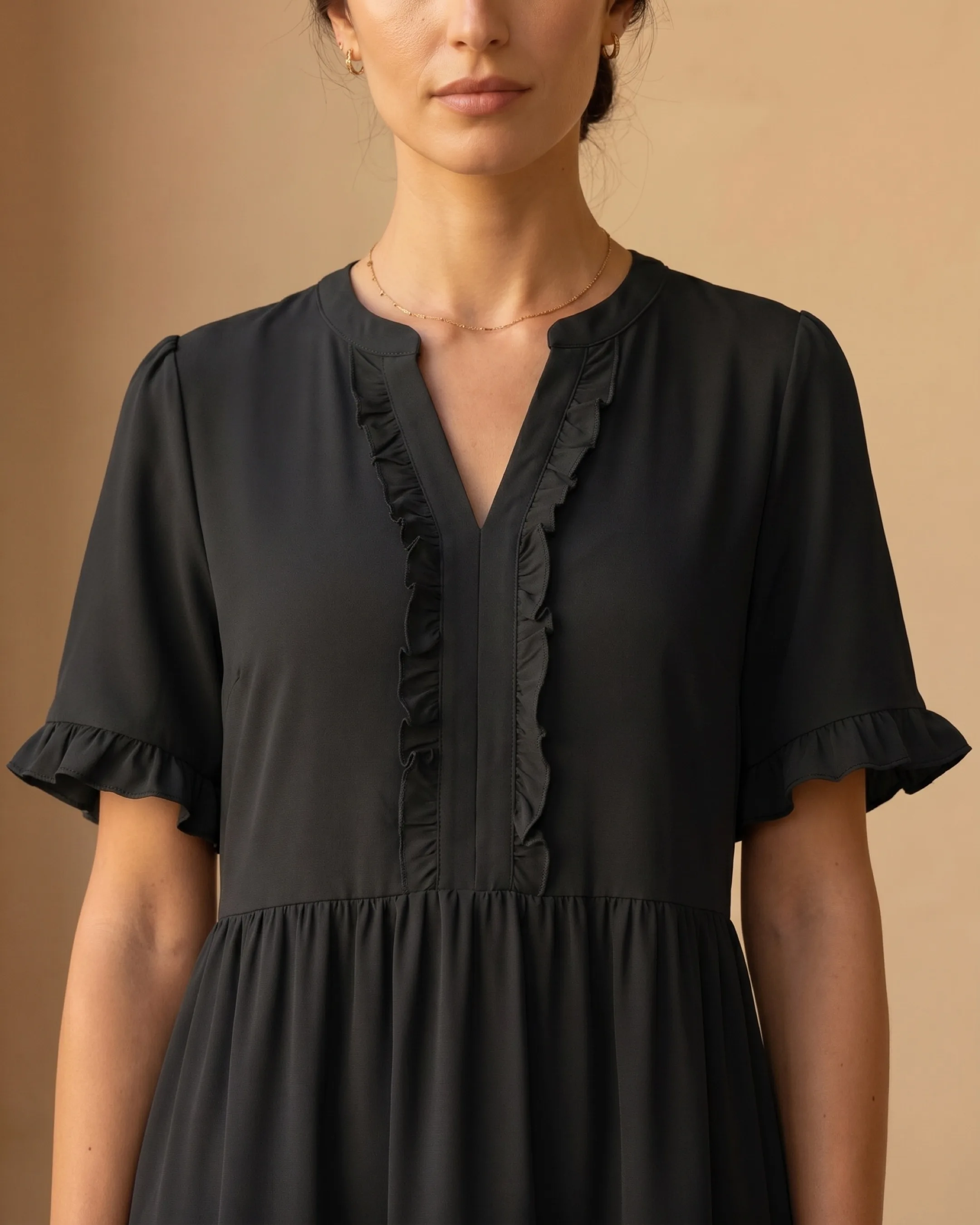 Hugo Caesar Tassi Tertulla close-up of the split V-neck, vertical ruffle-trim placket and flutter ruffle-cuff sleeves in black