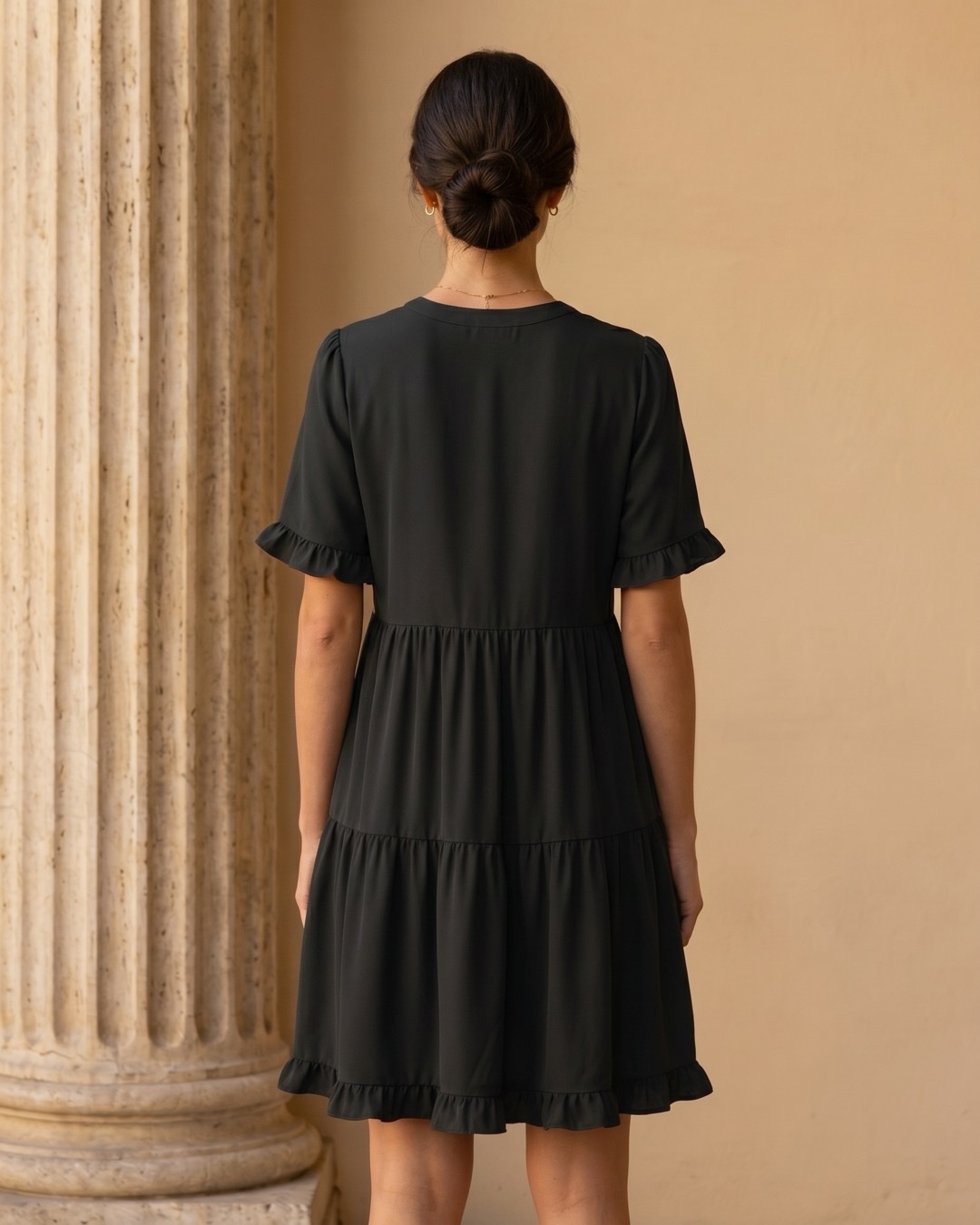 Hugo Caesar Tassi Tertulla full-length rear view showing the plain round back neckline, flutter sleeves and gathered tiered swing skirt