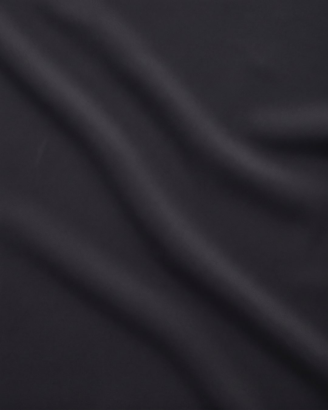 Close detail of the matte crepe and fine vertical knife-pleating of the Hugo Caesar Tassi Tullia evening gown