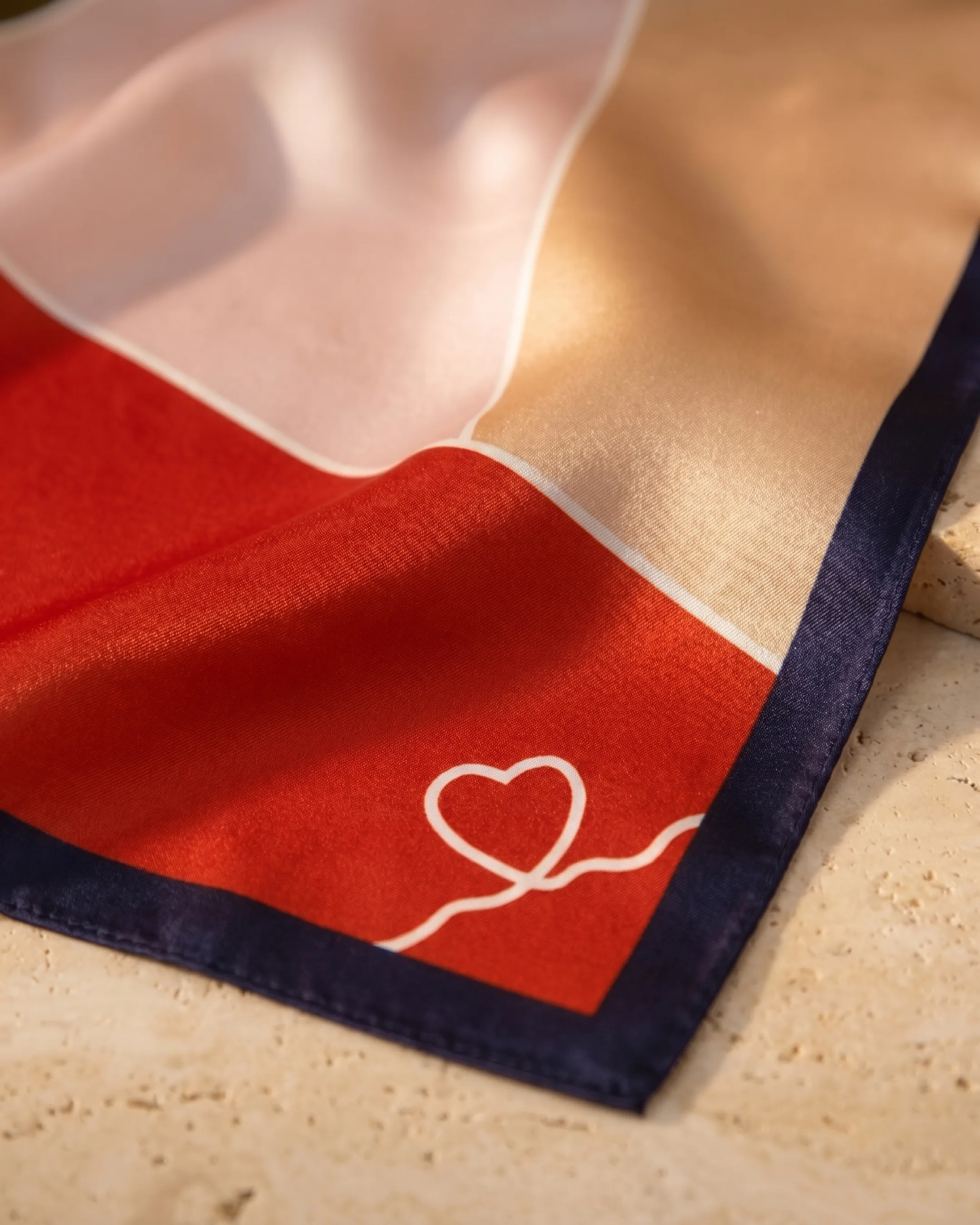Hugo Caesar Tassi Verona macro of the lustrous mulberry silk, the slim navy border and the hand-drawn heart motif on the vermilion panel