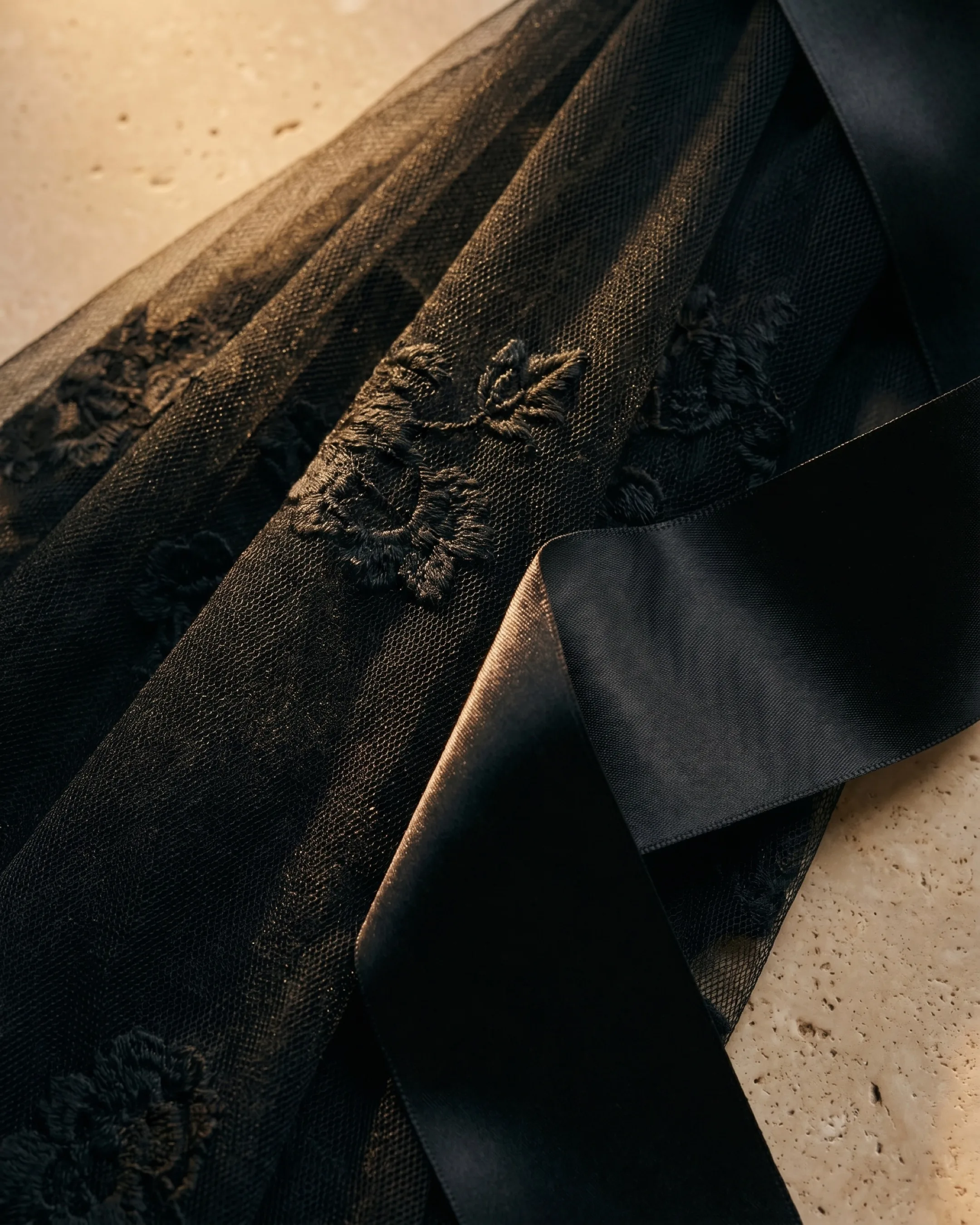 Hugo Caesar Tassi Volusia macro of fine black tulle with a tonal self-coloured floral relief and black satin ribbon
